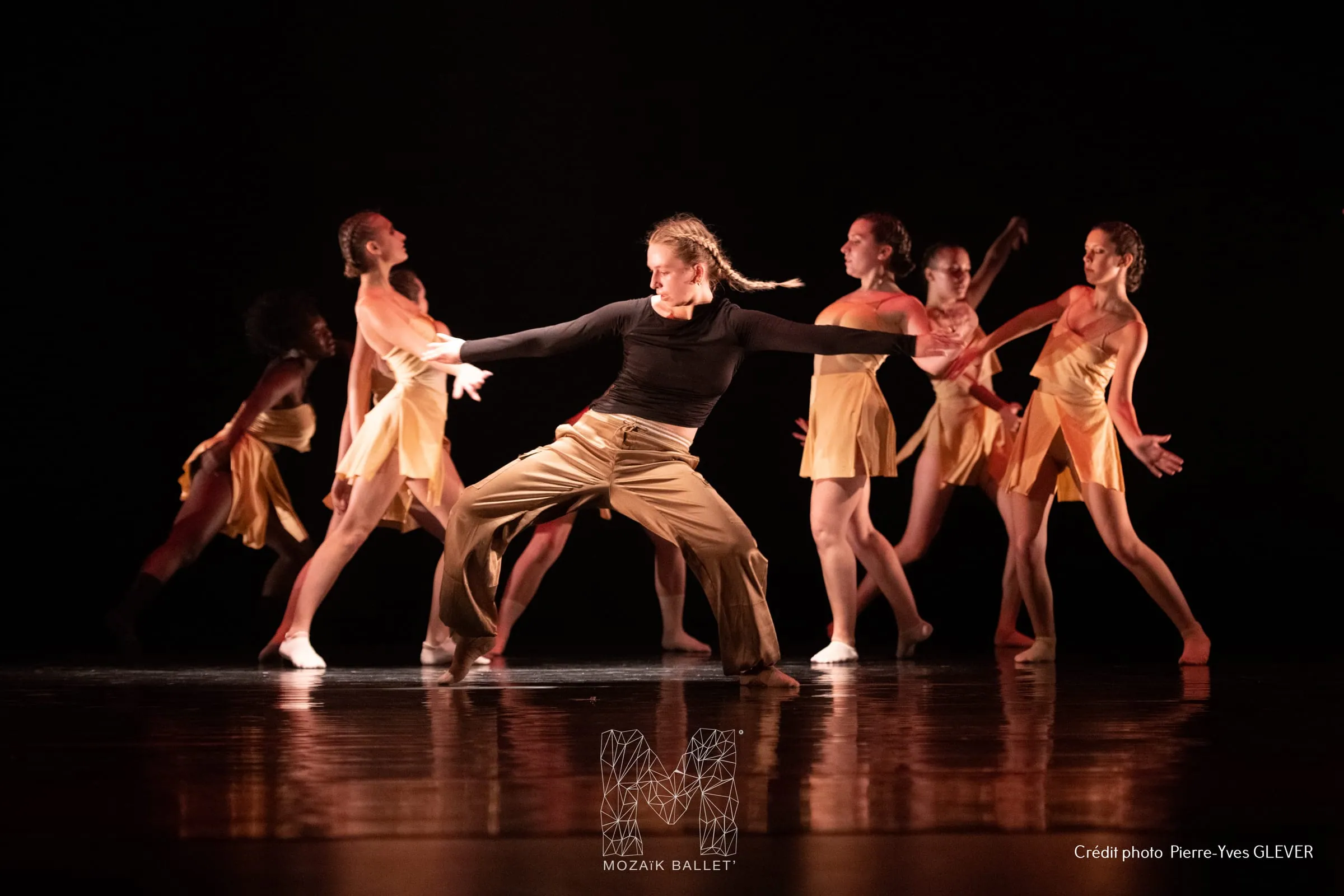Ensemble de la compagnie en scène, lumière chaude